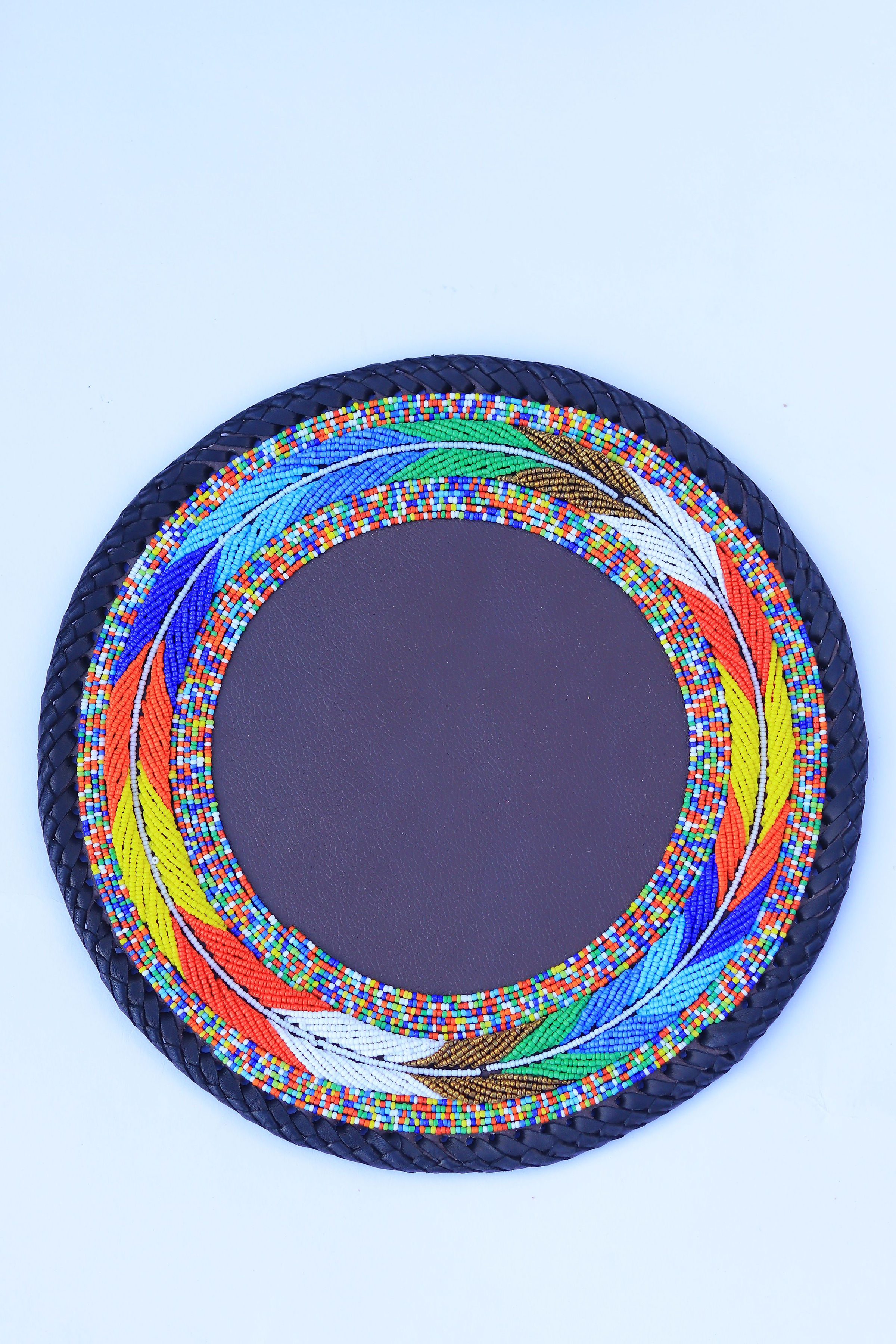 Round beaded place mat with vibrant multicolour feather border and dark leather centre